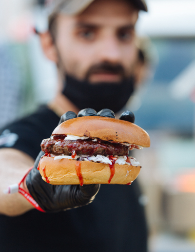Άνδρας κρατάει ένα ζουμερό burger - Thessaloniki Street Food Festival 2022, ΔΕΘ