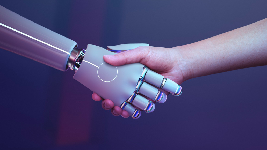 Θεματική εικόνα για το τι είναι η τεχνητή νοημοσύνη. Απεικονίζεται χειραψία ανάμεσα σε χέρι ρομπότ κι ανθρώπινο χέρι.