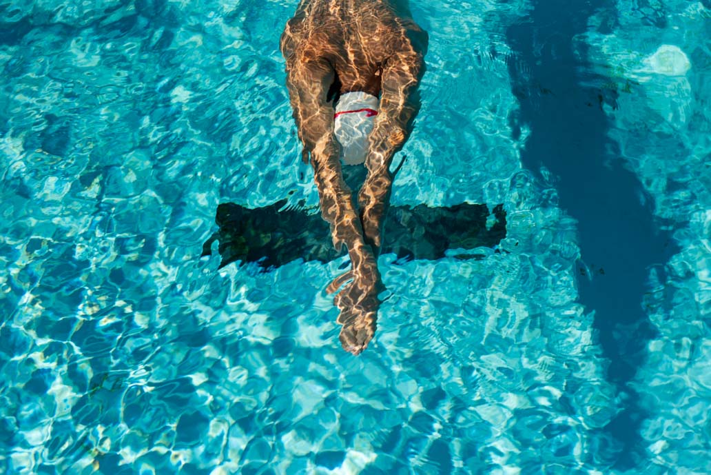 Άνθρωπος κάνει αερόβια γυμναστική, κολυμπώντας σε πισίνα.