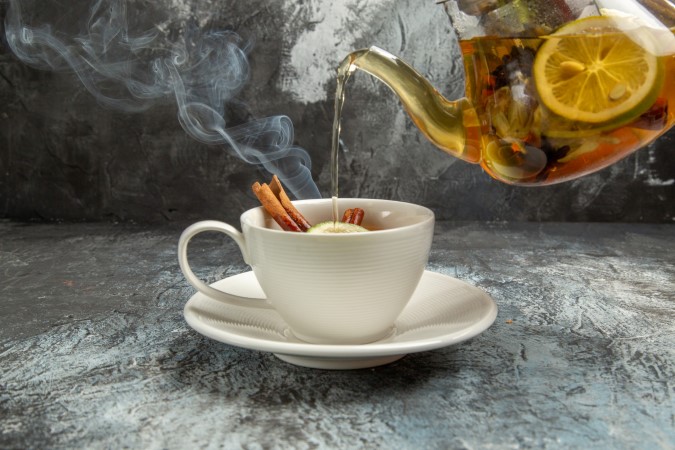 Ζεστό χειμωνιάτικο ρόφημα. Καυτό τσάι με μέλι και μπαχαρικά χύνεται μέσα σε κούπα.