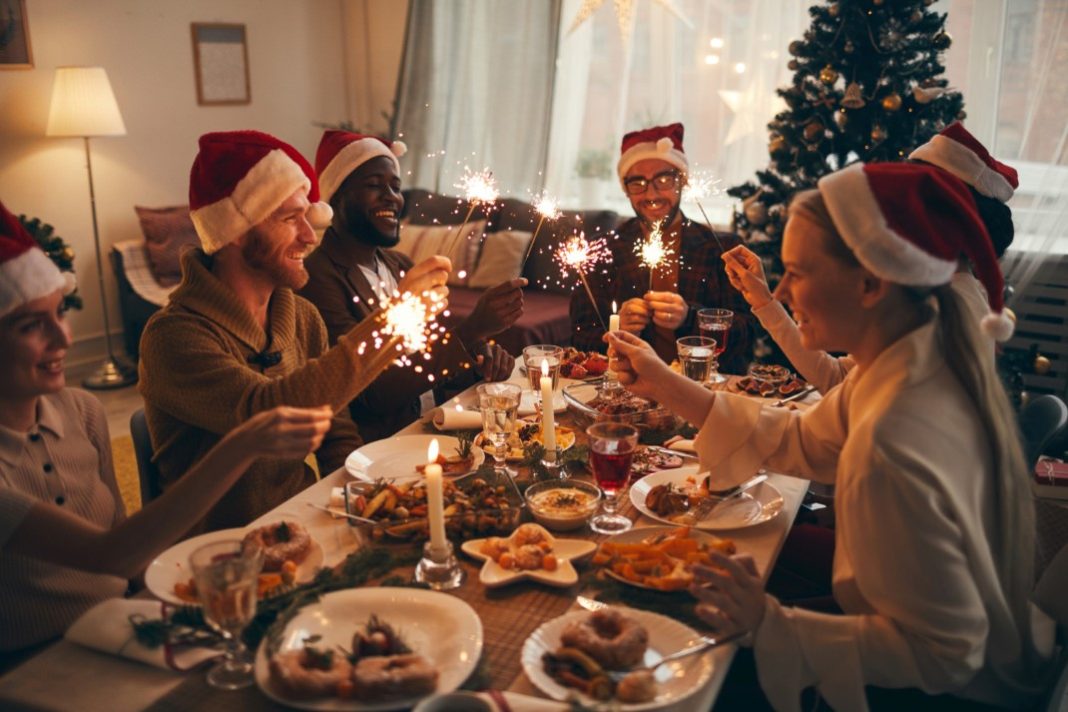 Θεματική εικόνα για το πώς να περάσεις ωραία τα Χριστούγεννα. Φίλοι έχουν μαζευτεί για το χριστουγεννιάτικο τραπέζι.