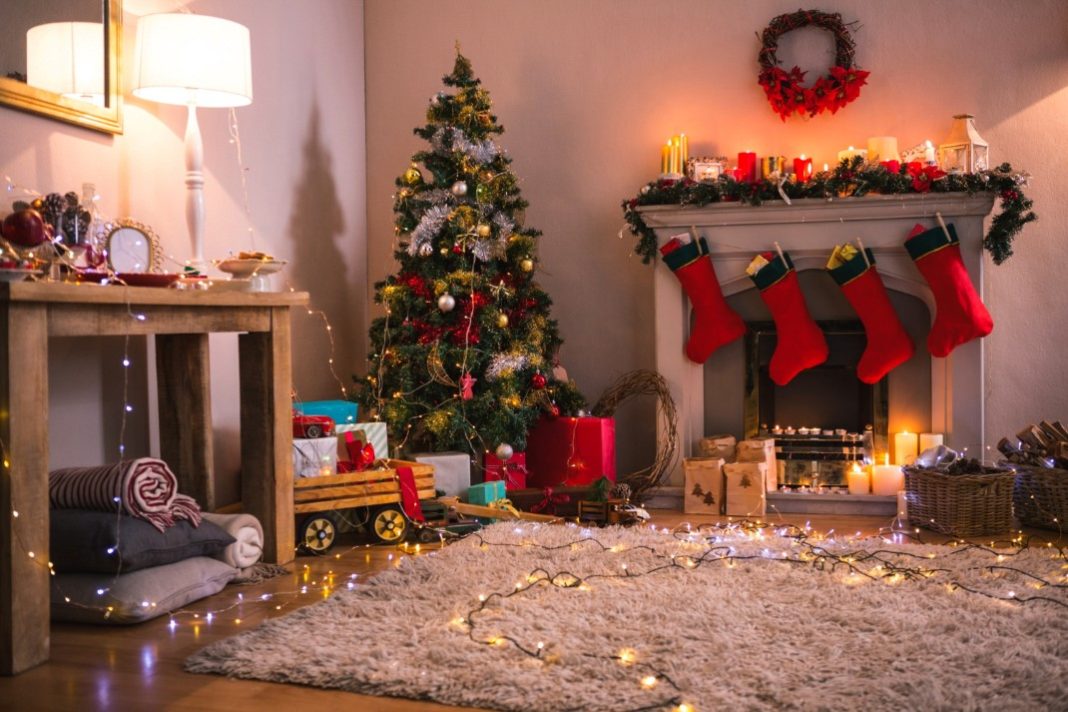 Θεματική εικόνα για το πώς να στολίσω το σπίτι τα Χριστούγεννα. Σαλόνι με χριστουγεννιάτικο δέντρο και στολισμένο τζάκι.