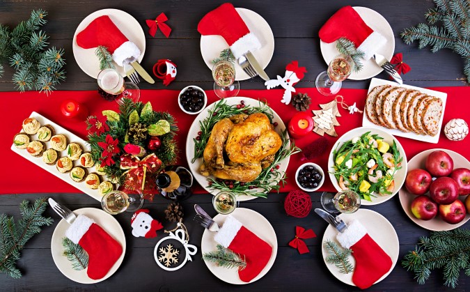 Χριστουγεννιάτικο τραπέζι με μια πιατέλα με ολόκληρο κοτόπουλο στη μέση.